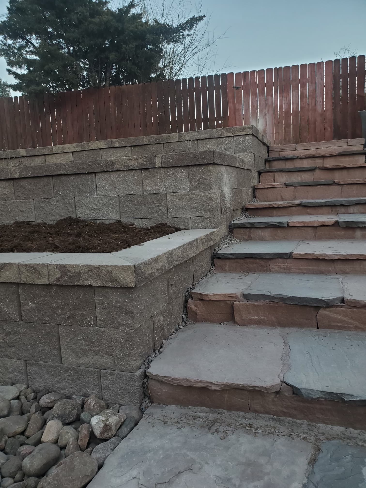 Flagstone patio with raised garden beds and retaining walls
