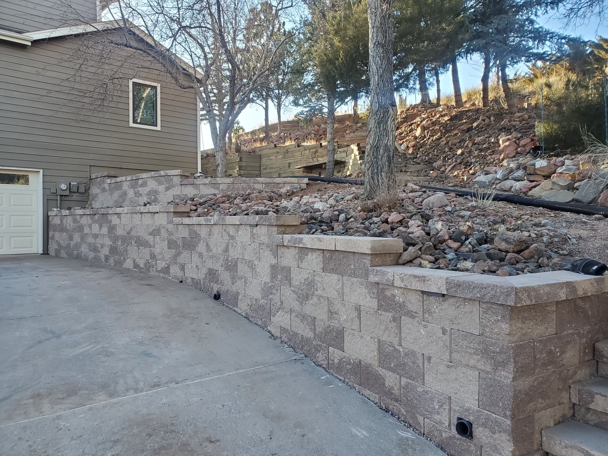 Tiered retaining wall with integrated steps and landscaping